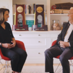 总理 Woodson interviewing Coach Laurie 对于这种情况 sitting in her home in front of two NCAA trophies.